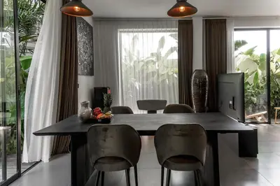 a dining room with a black table and chairs at Premier Umalas Villas in Seminyak