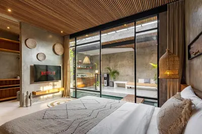 a bedroom with a bed and a large glass window at 10 mins to beach - BRAND NEW 1 BD w/Pool + Netflix in Canggu