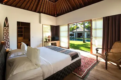 a bedroom with a bed and a large window at Villa Tiga Puluh, 7 Bedrooms Private Villa in Seminyak in Seminyak