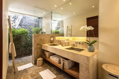a bathroom with a sink and a large mirror at Villa Tiga Puluh, 7 Bedrooms Private Villa in Seminyak in Seminyak