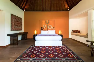 a bedroom with a bed and a table in a room at Villa Tiga Puluh, 7 Bedrooms Private Villa in Seminyak in Seminyak