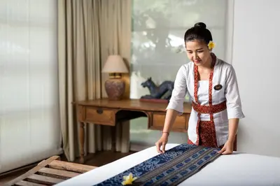a young girl making a bed in a room at Villa Tiga Puluh, 7 Bedrooms Private Villa in Seminyak in Seminyak