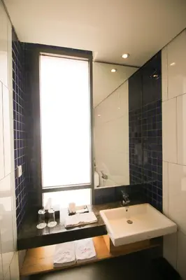 a bathroom with a sink and a large window at Liberta Hotel Jimbaran in Jimbaran