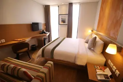 a hotel room with a bed and a desk at Liberta Hotel Jimbaran in Jimbaran