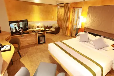 a hotel room with a large bed and a television at Liberta Hotel Jimbaran in Jimbaran