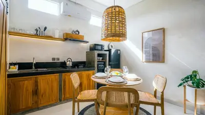 a kitchen with a table and chairs and a sink at Alaya Homes B - Stylish Japandi Loft Suite in Seminyak in Seminyak