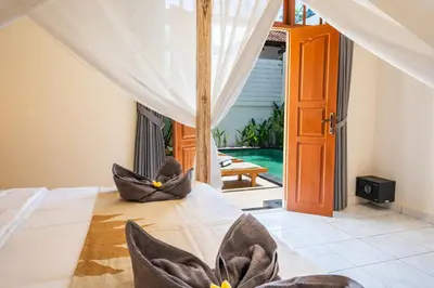 a bedroom with a bed with two chairs at Villa WES - Legian - 5 Bedroom - 4 Bath - Location in Seminyak