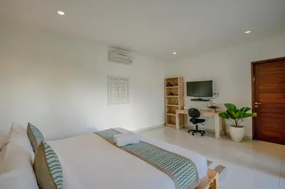 a bedroom with a bed and a desk and a television at Villa Alleira - 5 Bedroom Villa in Centre Location of Seminyak in Seminyak