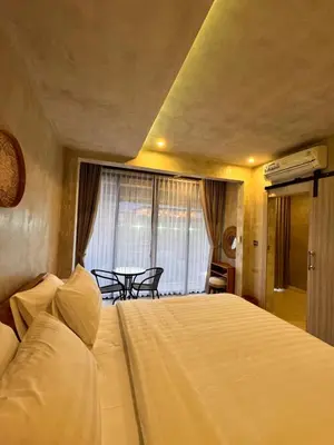 a hotel room with a large bed and a table at Villa de Mer Bali in Legian