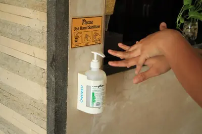a person is reaching for a bottle of hand sanitizer at The Light Exclusive Villas and SPA in Seminyak
