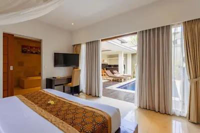 a bedroom with a bed and a desk and a television at The Light Exclusive Villas and SPA in Seminyak