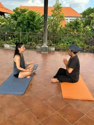 a man and a woman sitting on mats at Bali Telaga Hati Yoga Healing And Retreat Center Hostel in Sanur