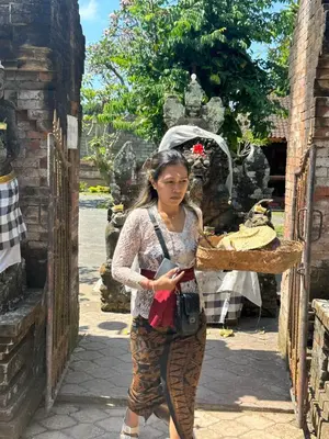 a woman is standing in front of a building at Bali Telaga Hati Yoga Healing And Retreat Center Hostel in Sanur