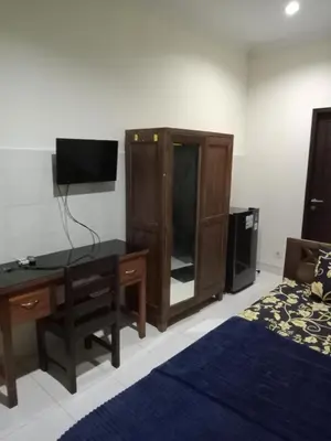 a bedroom with a desk and a bed at Bali Holiday Guesthouse near IALF & Benoa in Pesanggaran