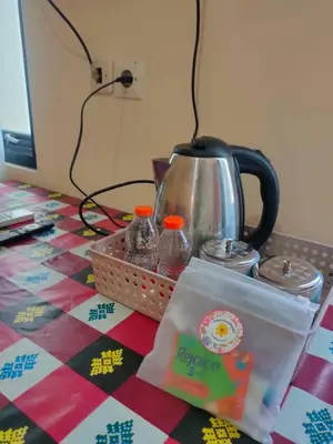 a table with a tea kettle and a box on it at Bali Holiday Guesthouse near IALF & Benoa in Pesanggaran