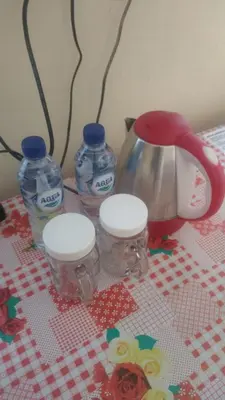 a table with two bottles of water and a tea kettle at Bali Holiday Guesthouse near IALF & Benoa in Pesanggaran