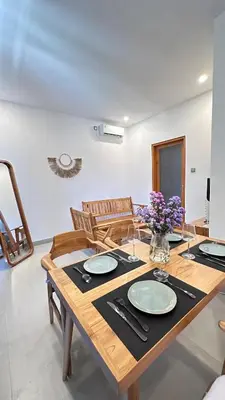 a dining room with a wooden table and chairs at 2 bedroom villa in Umalas in Kerobokan
