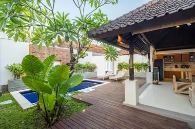 an outdoor entertaining area with a wooden deck and a pergola at 2 Bedroom Villa private Pool and BBQ Seminyak Bali in Seminyak
