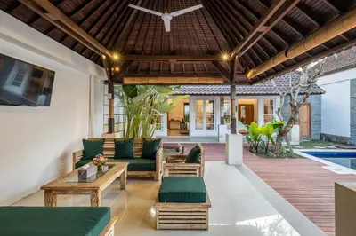 an outdoor patio with green furniture and a pool at 2 Bedroom Villa private Pool and BBQ Seminyak Bali in Seminyak