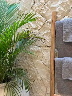 a stone wall with a chair and a plant at Villa Efire-3 bedroom with pool in Seminyak
