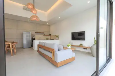 a living room with a couch and a kitchen at Villa Isea-3 bedroom with pool in Seminyak