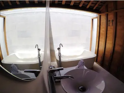 a bathroom with a sink and a tub and a mirror at Milavila in Seminyak