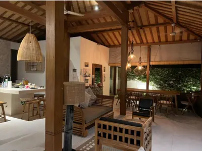 a pavilion with a couch and a table and chairs at Milavila in Seminyak