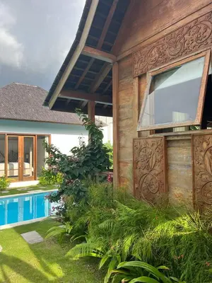 a house with a large window next to a swimming pool at Milavila in Seminyak