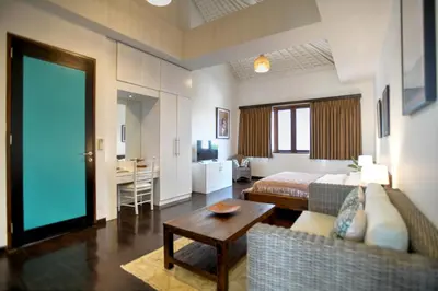 a living room with a couch and a bed and a table at Melo Suites Hotel in Seminyak