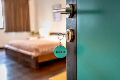 a door with a keychain in a room with a bed at Melo Suites Hotel in Seminyak