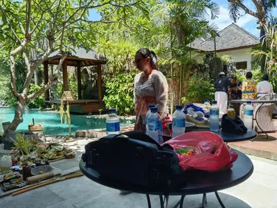 a woman standing next to a table with water bottles at Melo Suites Hotel in Seminyak