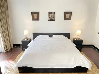 a bedroom with a large white bed with two night stands at Melo Suites Hotel in Seminyak