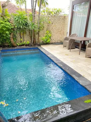 a swimming pool in the middle of a yard at Melo Suites Hotel in Seminyak