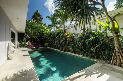 a swimming pool in front of a house at Villa Kallayaan by Optimum Bali Villas in Seminyak