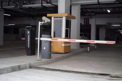 a barrier in a parking lot with a phone booth at Anagata 1 Tanjung Benoa Bali in Nusa Dua