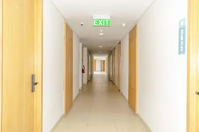 an empty hallway in a hospital with an exit sign on the ceiling at Anagata 1 Tanjung Benoa Bali in Nusa Dua