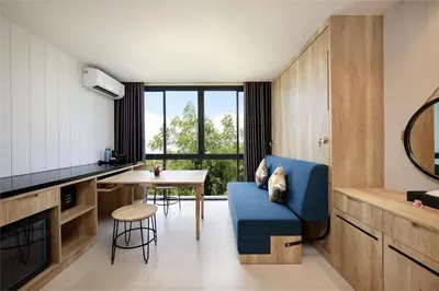 a living room with a blue chair and a table at Anagata 1 Tanjung Benoa Bali in Nusa Dua