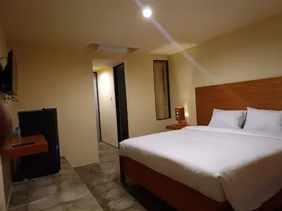 a bedroom with a large bed in a hotel room at Kuta Living by Kamara in Kuta