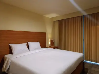 a large white bed in a hotel room at Kuta Living by Kamara in Kuta