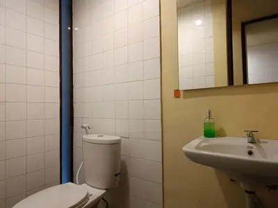 a bathroom with a toilet and a sink at Kuta Living by Kamara in Kuta