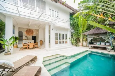 a swimming pool in front of a house at W villa in Seminyak