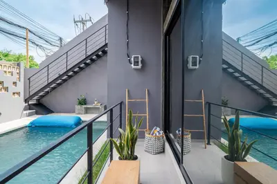an outdoor balcony with a swimming pool and stairs at Alaya Homes D - Chic Japandi Loft Suite in Seminyak in Seminyak