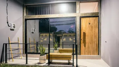 a balcony with two chairs and a wooden door at Alaya Homes D - Chic Japandi Loft Suite in Seminyak in Seminyak
