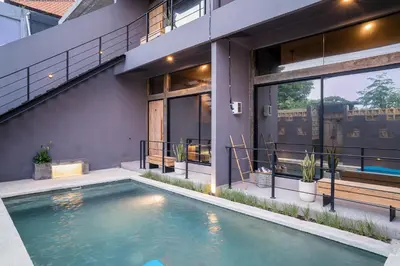 a swimming pool in front of a house at Alaya Homes D - Chic Japandi Loft Suite in Seminyak in Seminyak