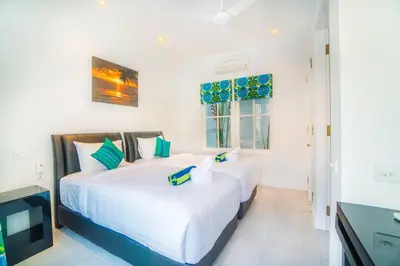 two white beds in a room with a television at Villa Ley Charming 2 Bedroom Villa Seminyak Private Pool in Seminyak