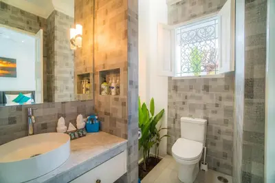 a bathroom with a sink and a toilet and a window at Villa Ley Charming 2 Bedroom Villa Seminyak Private Pool in Seminyak