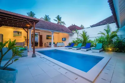 a swimming pool with blue chairs and a house at Villa Ley Charming 2 Bedroom Villa Seminyak Private Pool in Seminyak