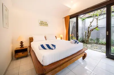 a bedroom with a bed and a large window at Villa Banua 3 Seminyak in Seminyak
