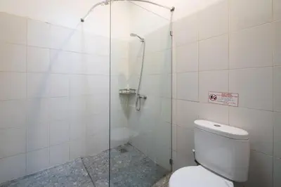 a bathroom with a toilet and a glass shower at Villa Banua 3 Seminyak in Seminyak