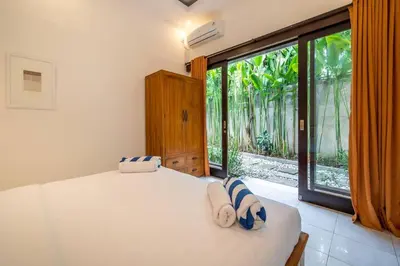 a bedroom with a bed and a large window at Villa Banua 3 Seminyak in Seminyak